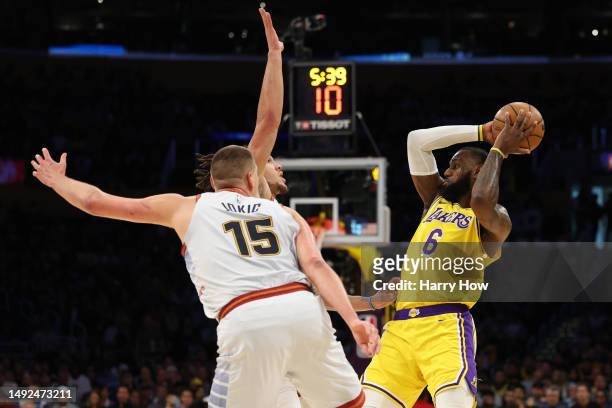 LeBron James of the Los Angeles Lakers looks to pass the ball in front of Aaron Gordon and Nikola Jokic of the Denver Nuggets during the first...