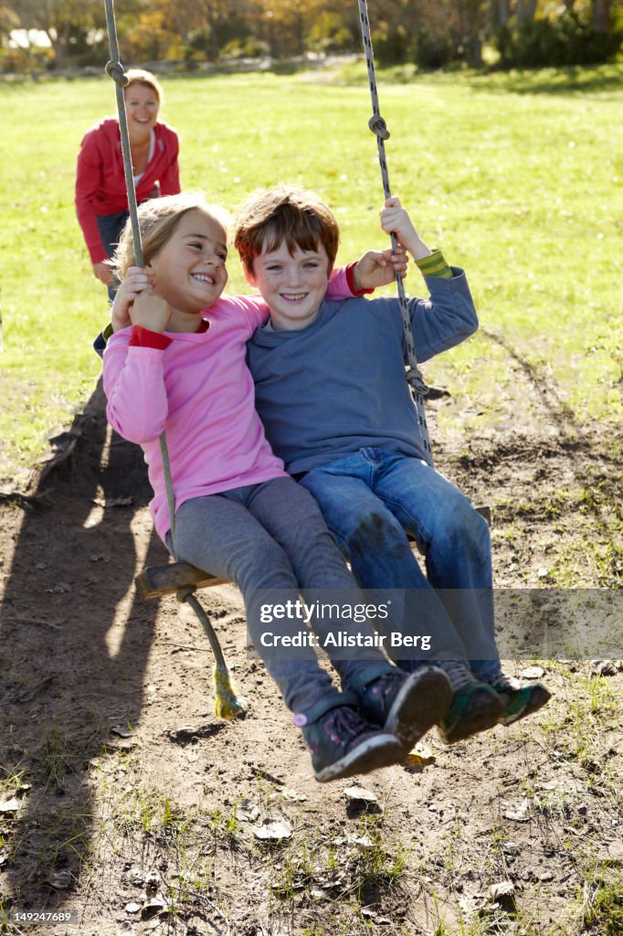 Children sitting on a swing together