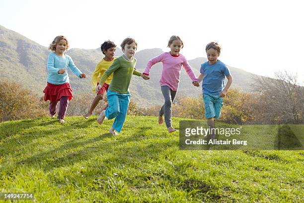 group of children running together - solo bambini foto e immagini stock
