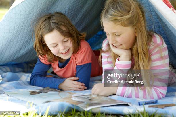 two girls looking at a book together - magazine retreat day 2 stock pictures, royalty-free photos & images