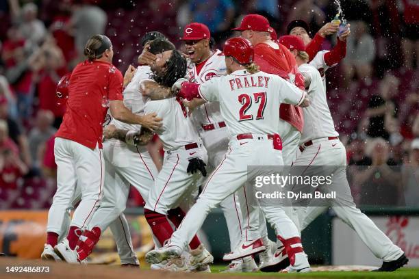 Nick Senzel of the Cincinnati Reds celebrates with teammates his walk-off sacrifice fly in the 10th inning to beat the St. Louis Cardinals 6-5 at...