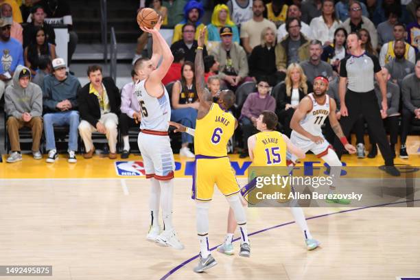 Nikola Jokic of the Denver Nuggets shoots the ball over LeBron James of the Los Angeles Lakers during the first half in game four of the Western...