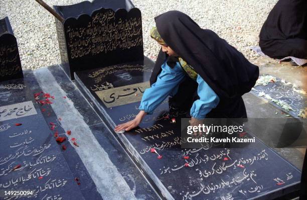 The young daughter of a diplomat slain by Taliban in Iran's Consulate in Mazar Sharif, Afghanistan cleans her father's tomb in Behesht Zahra...