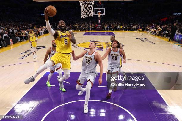 LeBron James of the Los Angeles Lakers scores on a layup in front of Nikola Jokic of the Denver Nuggets during the third quarter in game four of the...