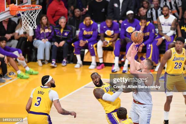 Nikola Jokic of the Denver Nuggets is called for an offensive foul against LeBron James of the Los Angeles Lakers during the second half in game four...