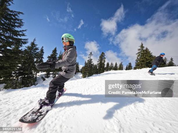 multiracial senior couple snowboarding together on sunny ski slope - skiing and snowboarding stock pictures, royalty-free photos & images