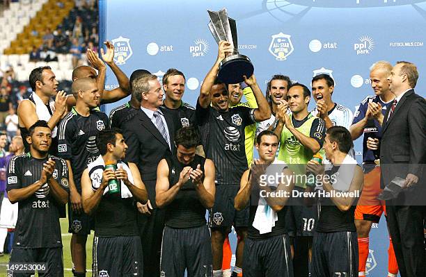 Dwayne De Rosario of MLS All-Stars holds the trophy among his teammates after defeating Chelsea in the 2012 AT&T MLS All-Star Game at PPL Park on...
