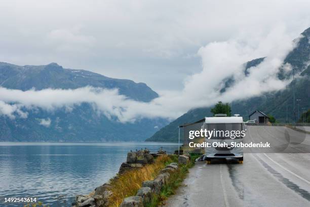 camper van parked near the lake in norway during the rain - awning stock pictures, royalty-free photos & images