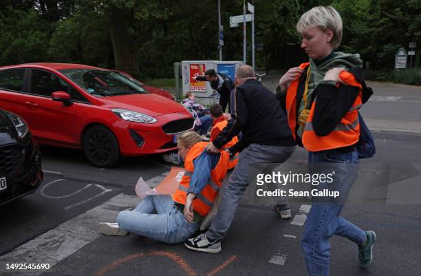 Irate motorists attempt to remove activists of the Last Generation climate action group who had blocked Puschkinallee avenue on May 23, 2023 in...