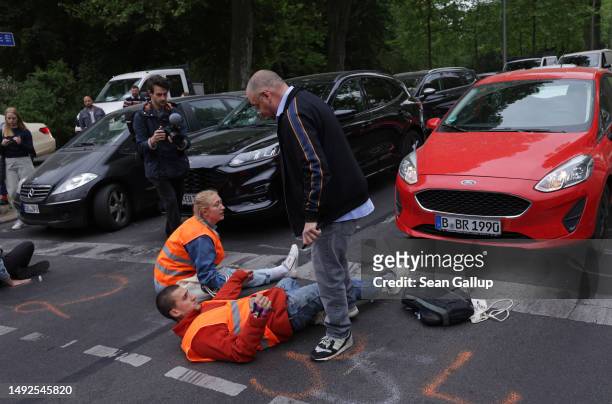 An irate motorist confronts activists of the Last Generation climate action group who had blocked Puschkinallee avenue on May 23, 2023 in Berlin,...