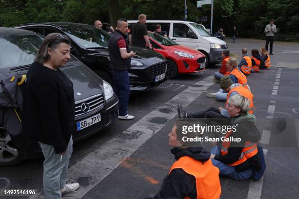 Motorists and bystanders confront activists of the Last Generation climate action group who had blocked Puschkinallee avenue on May 23, 2023 in...