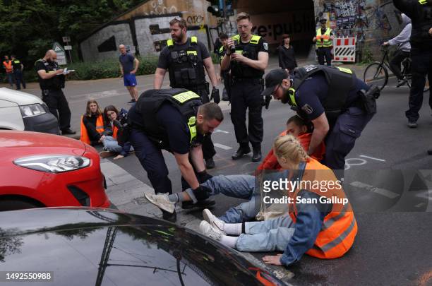 Police prepare to remove activists of the Last Generation climate action group whose hands were glued to one another and who, along with several...