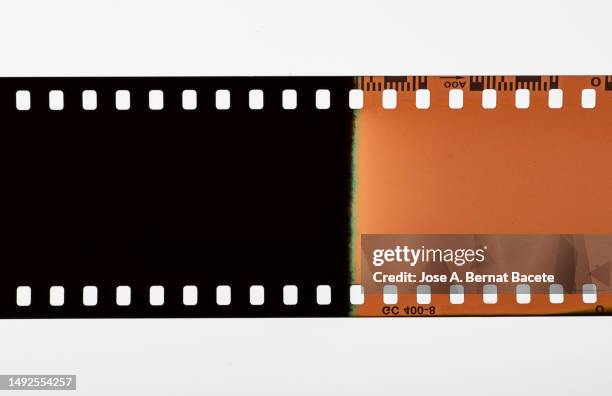 color negative 35mm film stripes on a white background. - cinta de película fotografías e imágenes de stock