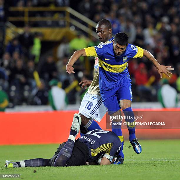 Goalkeeper Sebastian D'angelo and player Franco Sosa of Argentina's Boca Juniors vie for the ball with Wason Renteria of Colombian Millonarios during...