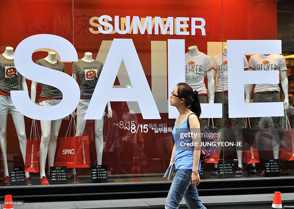 A woman walks past a sign advertising a 