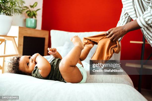 mom getting baby dressed - changing diaper stock pictures, royalty-free photos & images