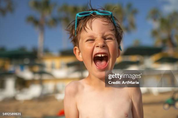il bambino sveglio che porta gli occhiali da sole gode delle vacanze estive al mare - gridare foto e immagini stock