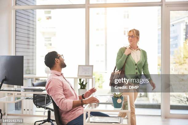 a businesswoman greeting her colleague while leaving the office. man and woman saying hello to the team or colleague while walking through a startup - verlaten stockfoto's en -beelden