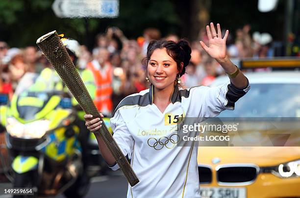 In this handout image provided by LOCOG, Torchbearer 151 Eliza Caird aka Eliza Doolittle carries the Olympic Flame on the Torch Relay leg between the...