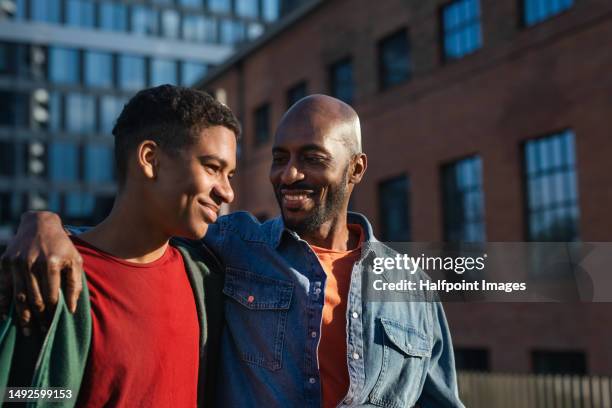 father walking with his son in a city. - dad and teen stock pictures, royalty-free photos & images
