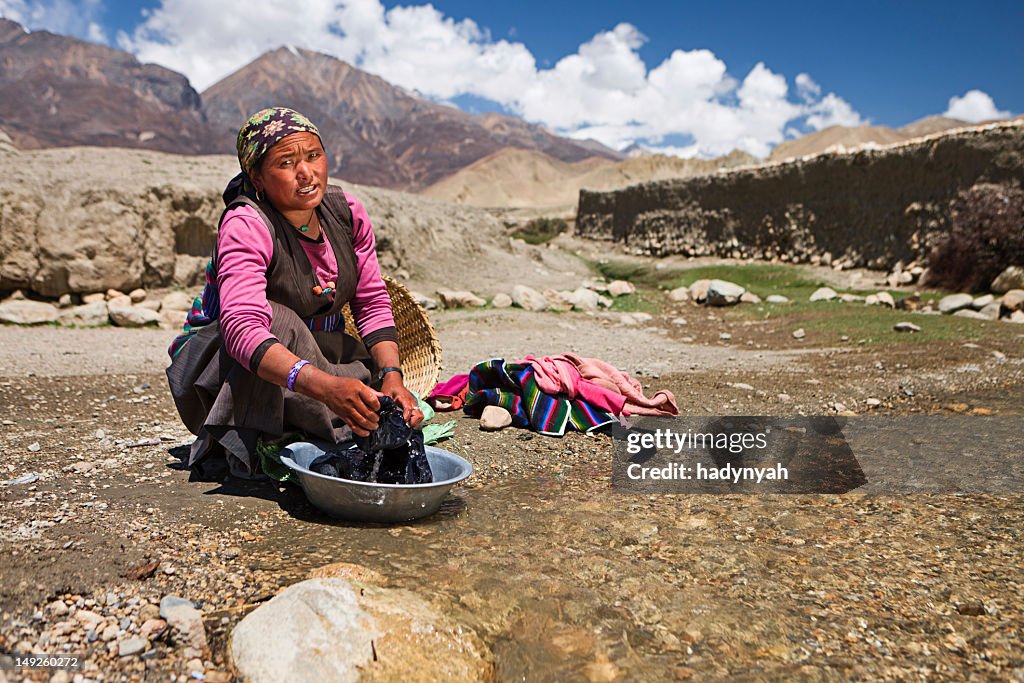 Tibetische Frau Waschen Kleidung in den Fluss.   Mustang.