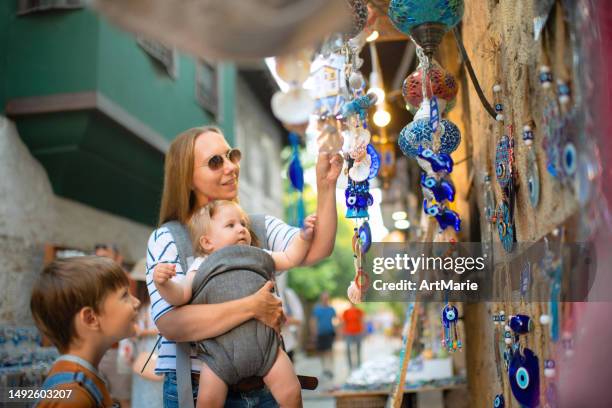 familie kauft auf einem souvenir-straßenmarkt in der altstadt von kaleici ein, während sie in antalya, türkei, unterwegs ist - antalya city stock-fotos und bilder