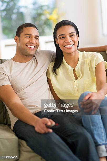 usa, new jersey, jersey city, couple watching tv at home - african american watching tv stock pictures, royalty-free photos & images