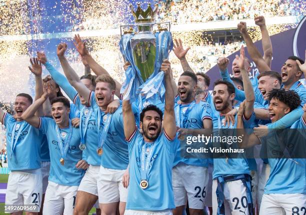 Manchester City captain Ilkay Gundogan lifts the Premier League trophy in front of team mates after the Premier League match between Manchester City...