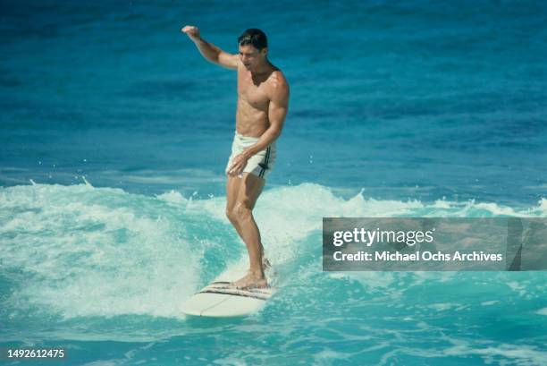 American actor Jan-Michael Vincent surfing while filming 'Big Wednesday', at Sunset Beach, on the north shore of Oahu , Hawaii, September 1977....