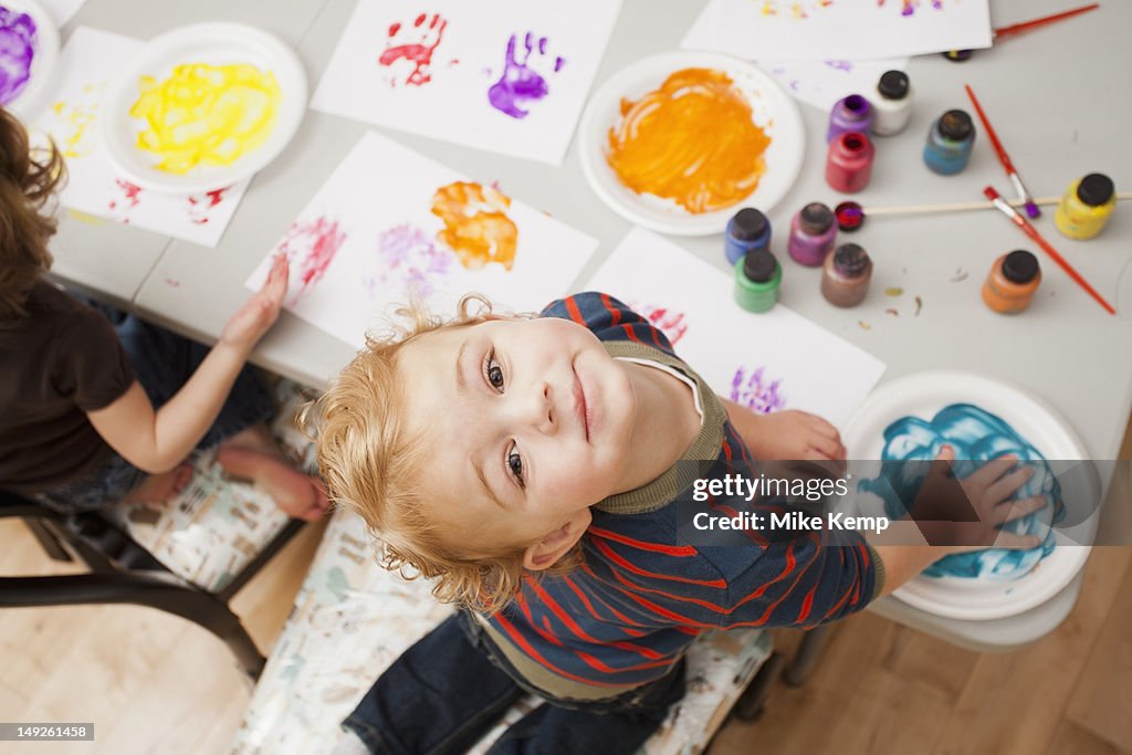 High angle view of boy (4-5) making palm print