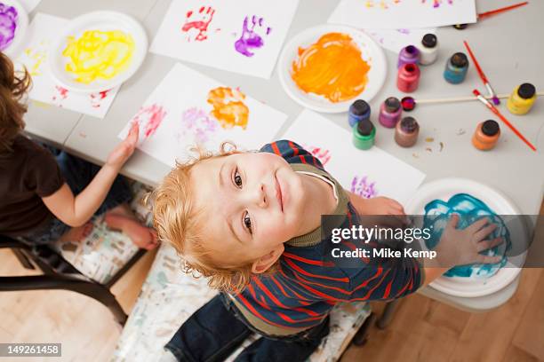 high angle view of boy (4-5) making palm print - kindergarten children stockfoto's en -beelden