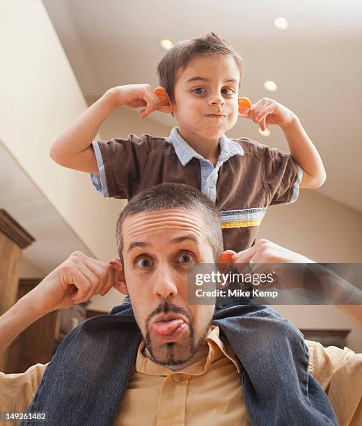 father and son (6-7) pulling funny faces - pulling ear stock pictures, royalty-free photos & images