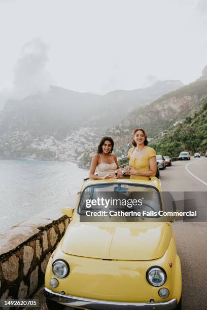 two woman enjoy experiential travel in a rented vintage car in italy - experiential vacations stock pictures, royalty-free photos & images