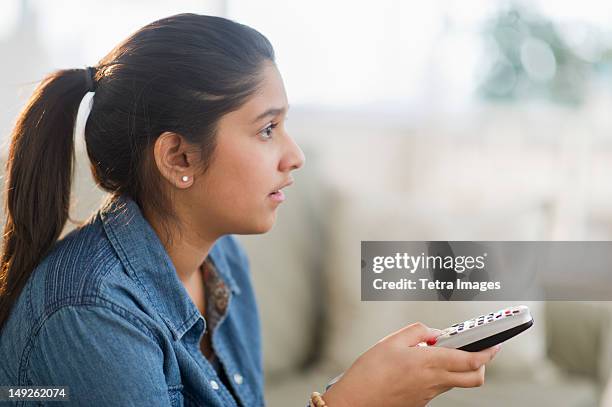 usa, new jersey, jersey city, girl (12-13) holding remote control - children only ponytail stock-fotos und bilder