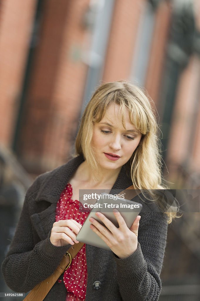 USA, New Jersey, Jersey City, Woman using digital tablet on street