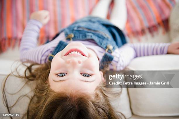 usa, new jersey, jersey city, small girl (4-5 years) lying on sofa - 4 5 years foto e immagini stock