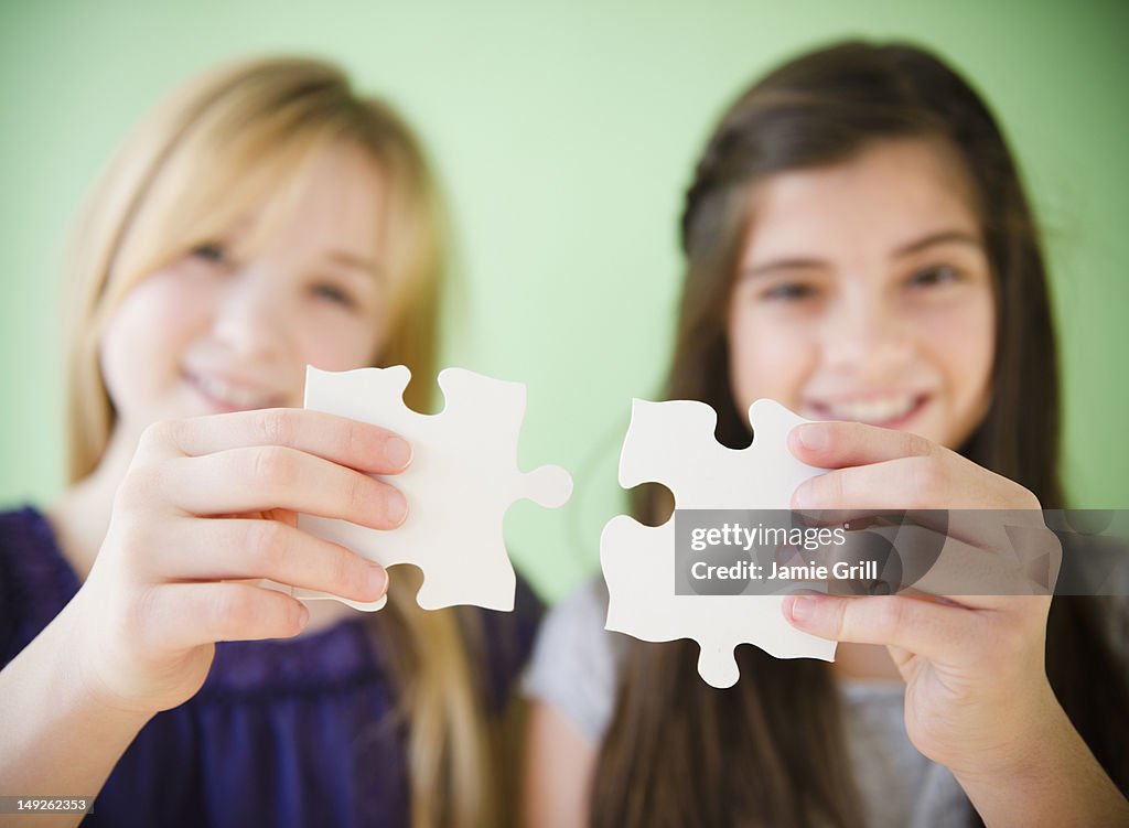 USA, New Jersey, Jersey City, Close up of hands of girls holding jigsaw puzzles