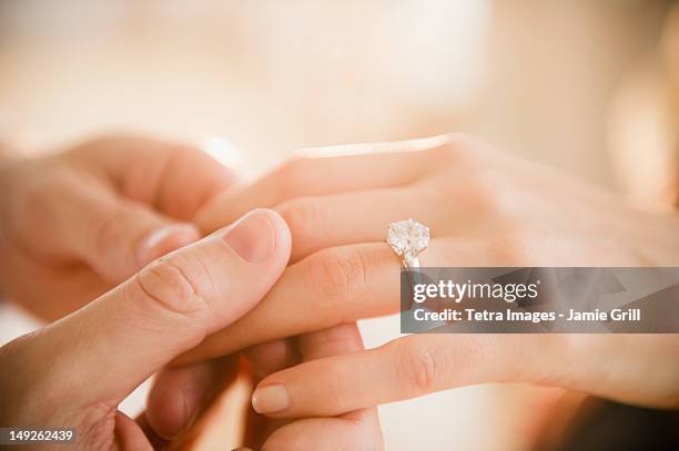 usa, new jersey, jersey city, close up of man's and woman's hands with engagement ring - engagement ring foto e immagini stock