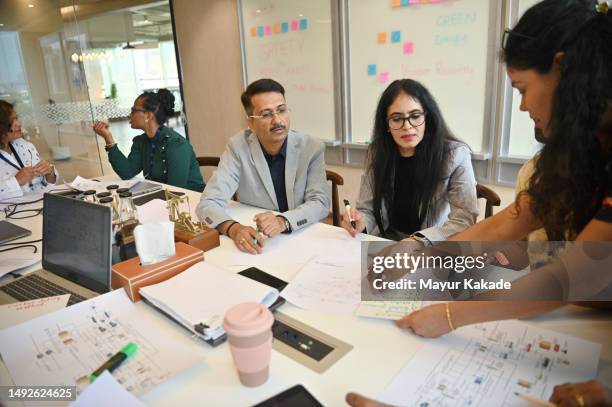 a diverse group of engineers discussing together in the meeting room - women on laptop stock pictures, royalty-free photos & images