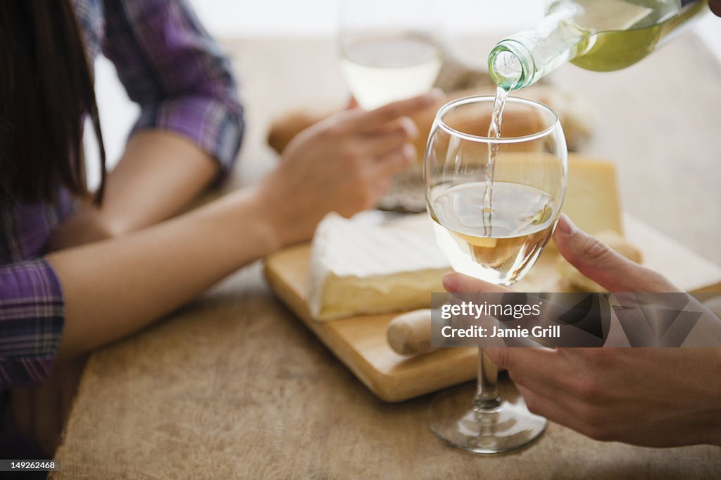 Close up of couple pouring wine and dining