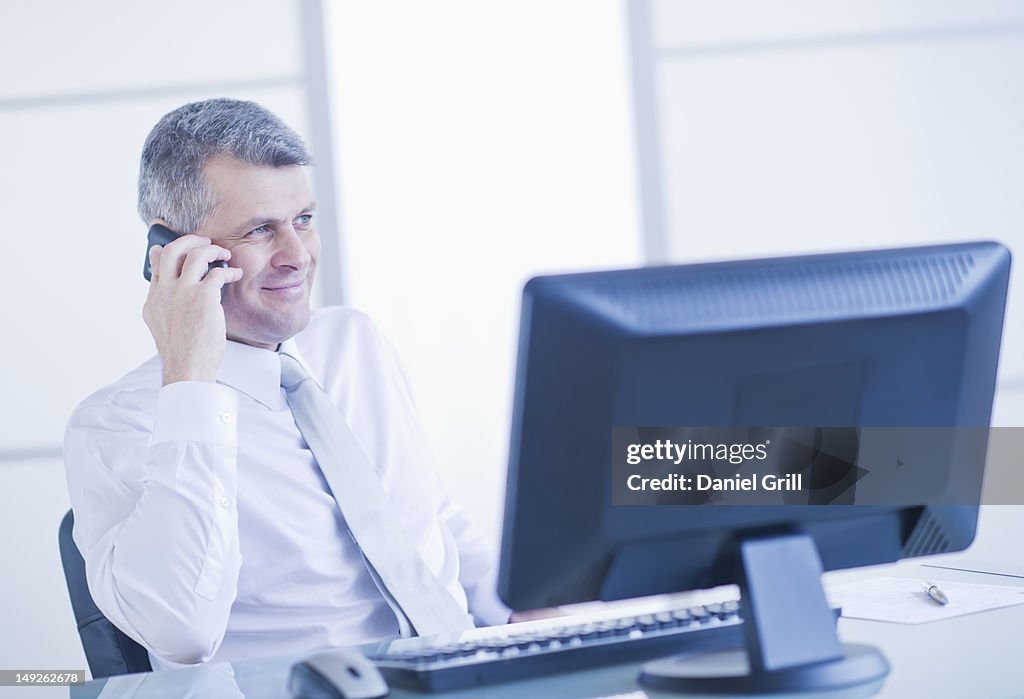 Man with mobile phone sitting in office