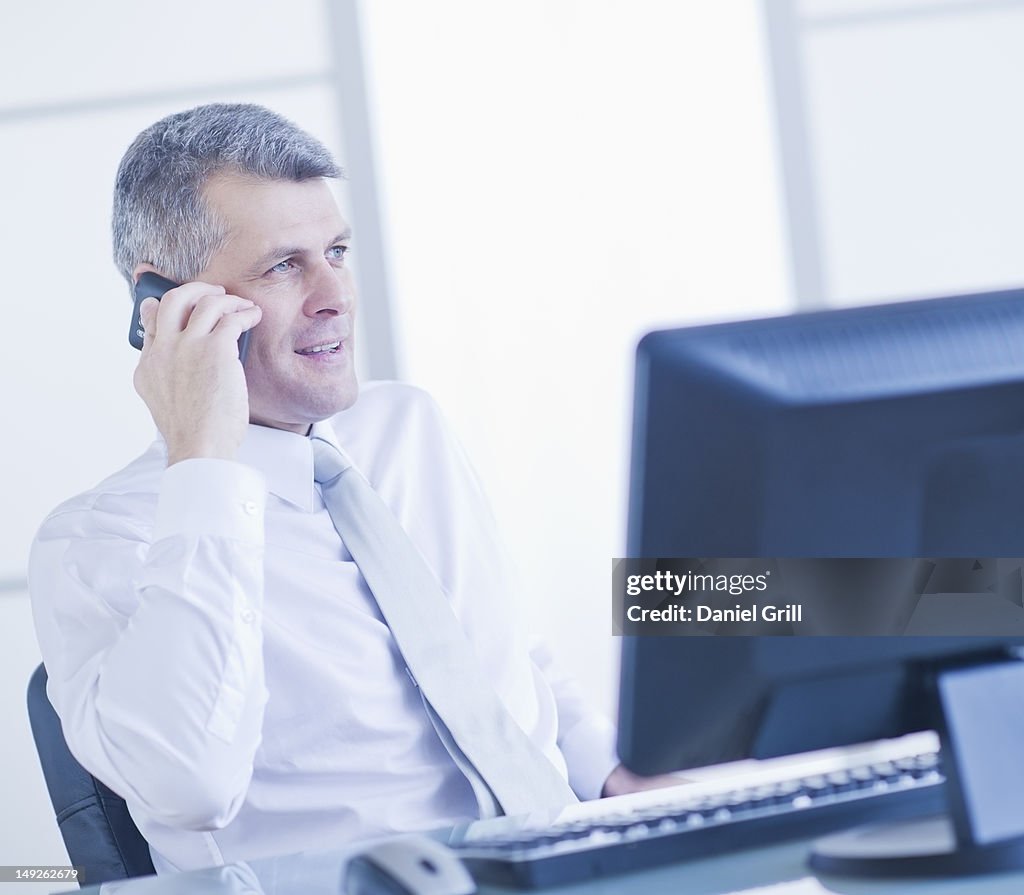 Man with mobile phone sitting in office