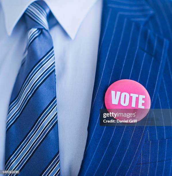 vote pin on man's lapel - revers stock-fotos und bilder