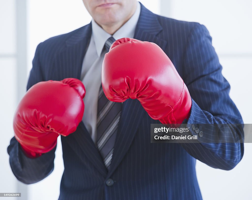 Businessman wearing red boxing gloves
