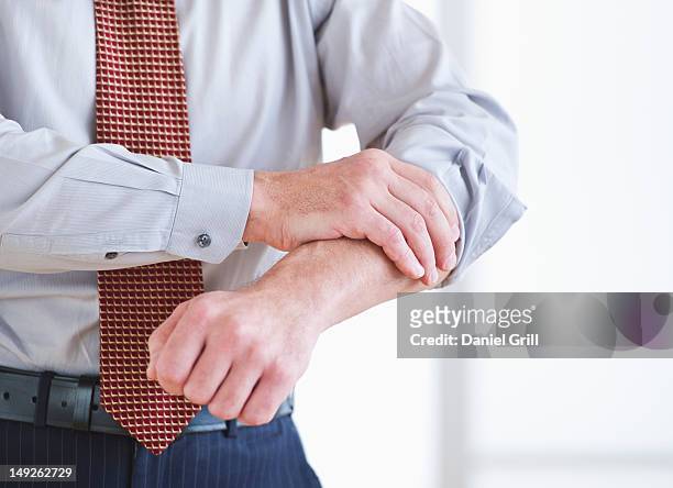 man rolling up sleeves - sleeve roll stock pictures, royalty-free photos & images