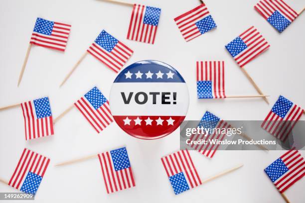 studio shot of vote pin and small american flags - campaign button stock pictures, royalty-free photos & images