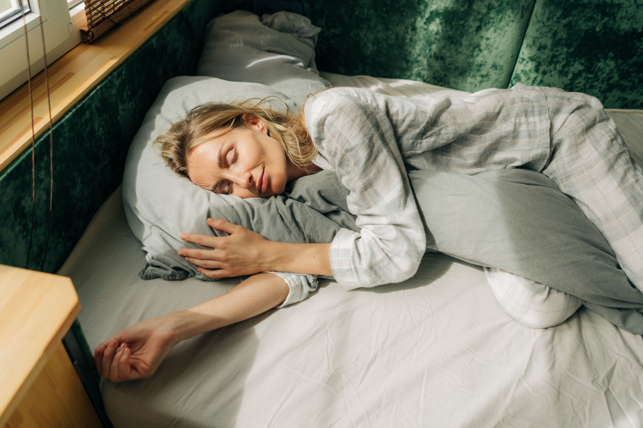 Portrait of a woman sleeping on a bed by the window. Day useful relaxing sleep. Portrait of a woman sleeping on a bed by the window. Day useful relaxing sleep.