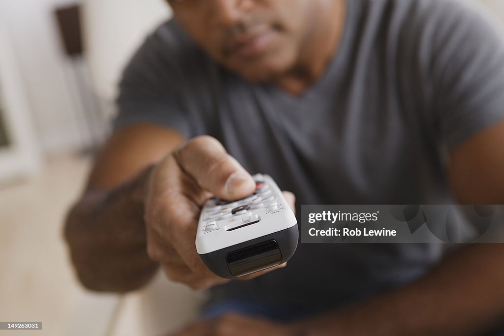 USA, California, Los Angeles, Mature man holding remote control, focus on foreground