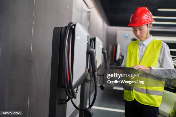 inspeção de estações de carregamento de veículos elétricos inteligentes - homens de idade mediana - fotografias e filmes do acervo