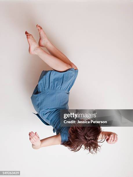 young woman wearing blue dress falling upside down - women in slips stock pictures, royalty-free photos & images